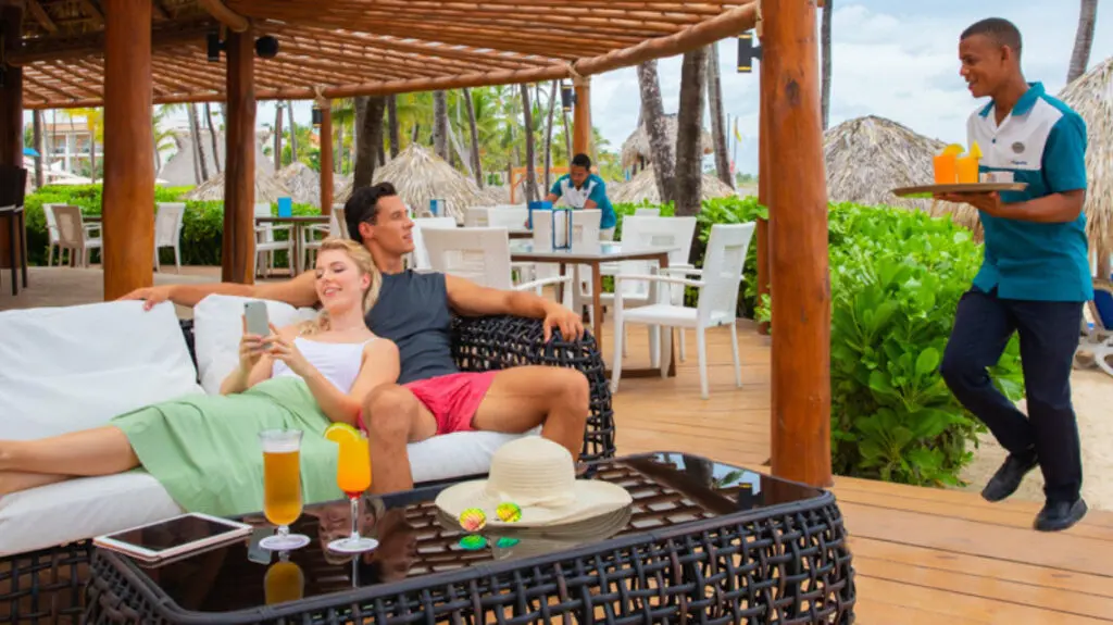 Hideaway at Royalton Punta Cana_couple relaxing about to receive drinks from server